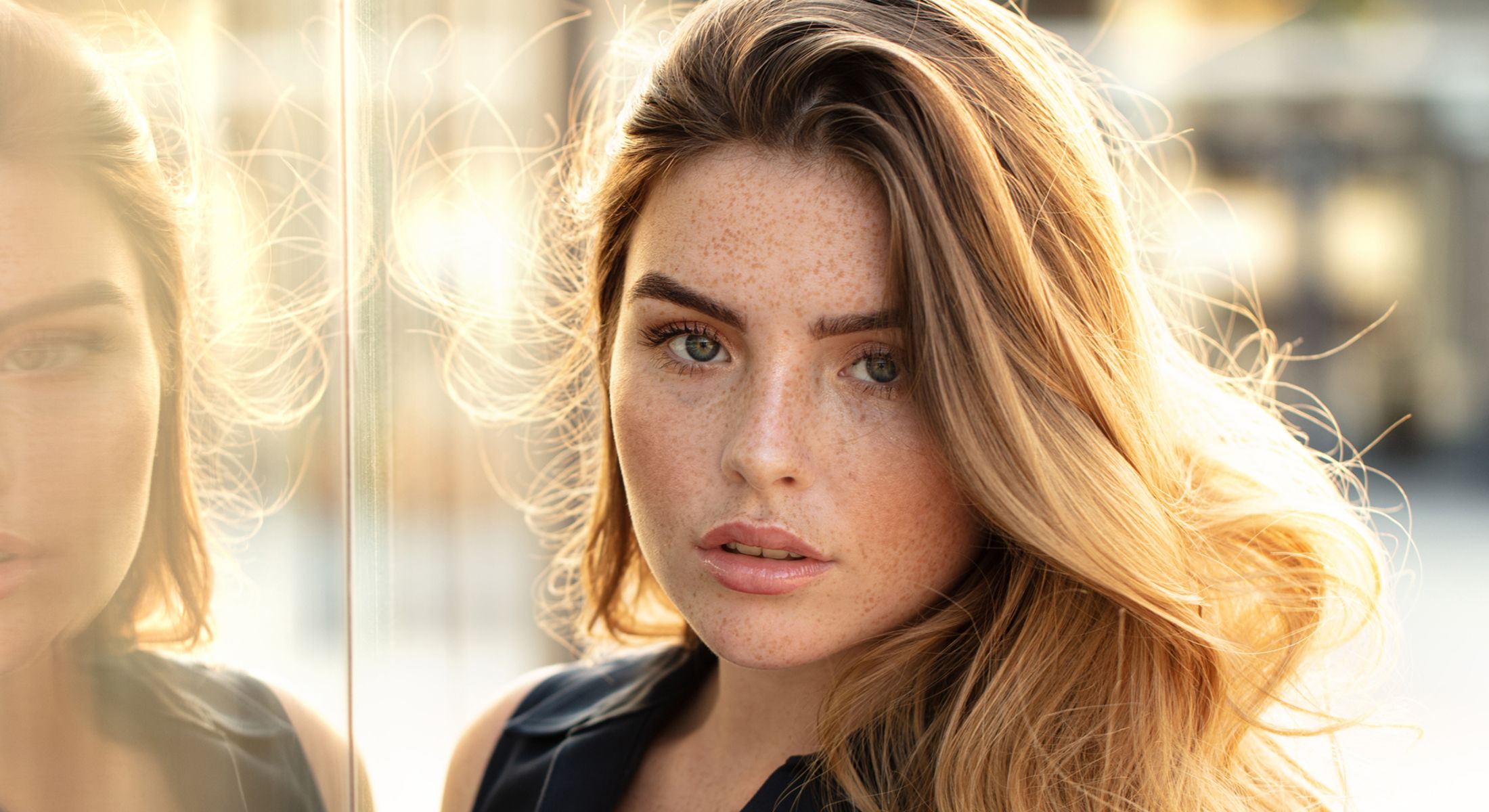 Young woman with wavy hair and freckles.