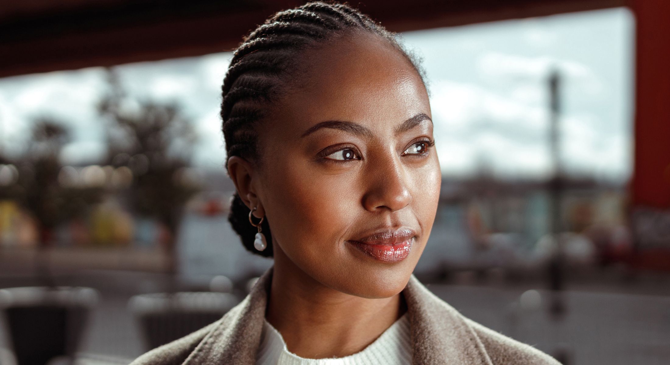 Woman in blue sweater posing thoughtfully.