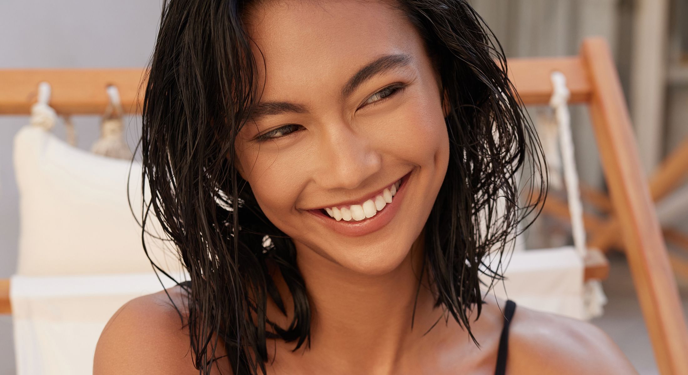 Smiling person with wet hair in casual setting.