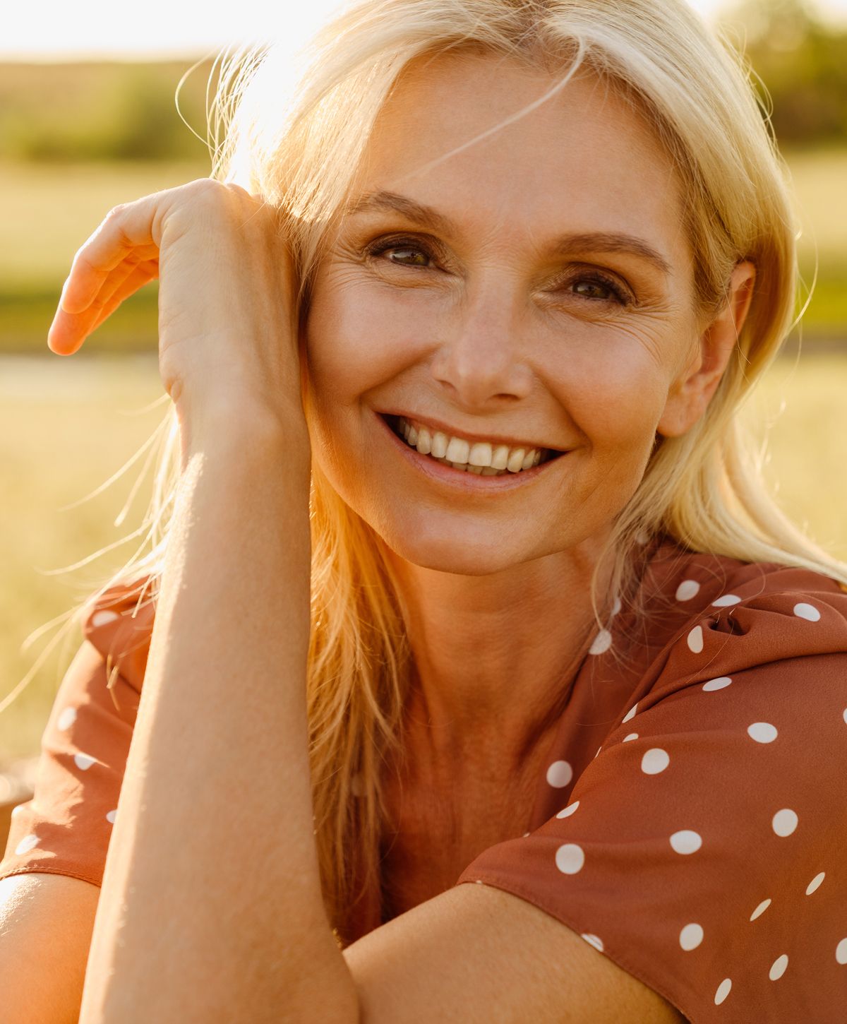 Smiling woman enjoying a sunny outdoor moment.
