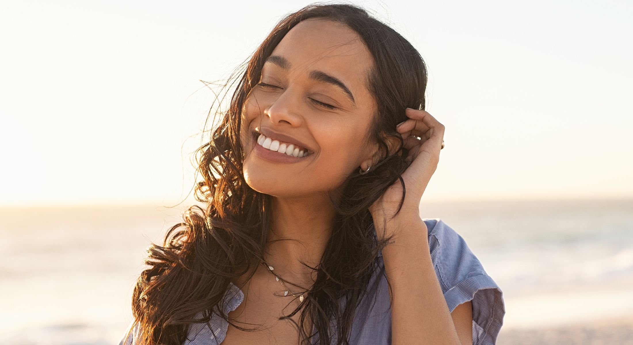 Smiling woman enjoying a sunny beach day.
