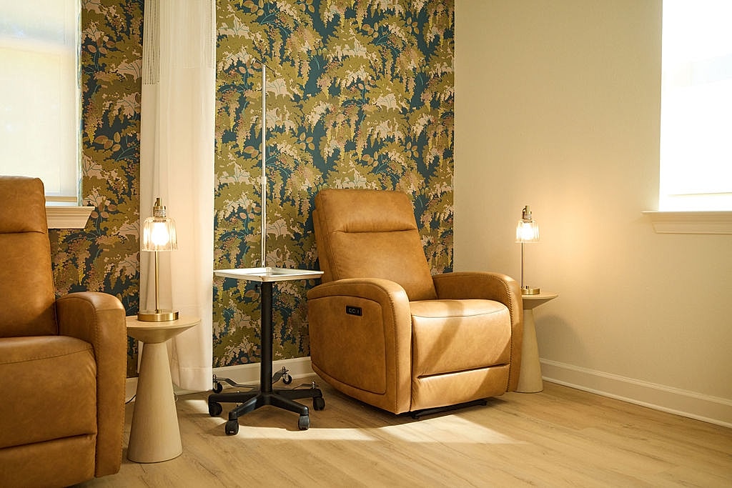 Cozy seating area with patterned wallpaper and lamps.